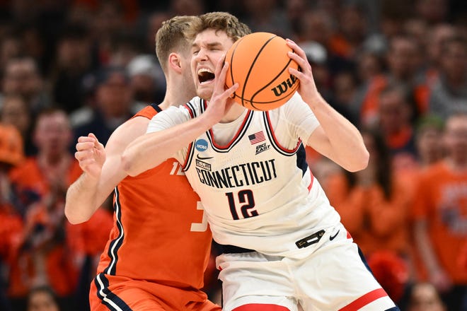 Mar 30, 2024; Boston, MA, USA; Connecticut Huskies guard Cam Spencer (12) dribbles the ball against Illinois Fighting Illini forward Marcus Domask (3) in the finals of the East Regional of the 2024 NCAA Tournament at TD Garden. Mandatory Credit: Brian Fluharty-USA TODAY Sports