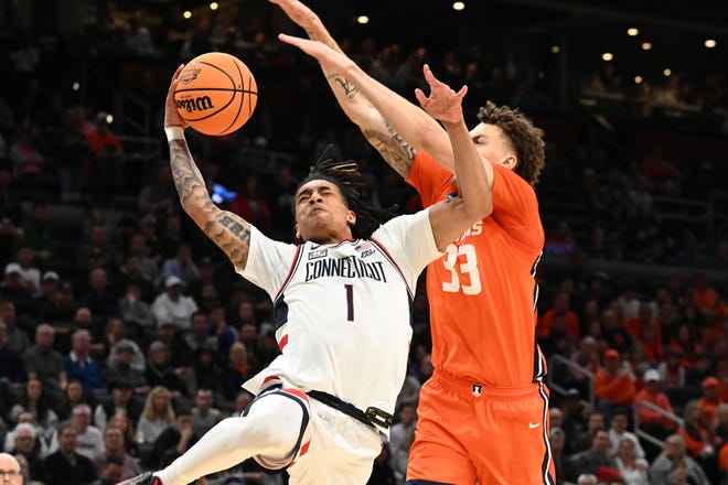Mar 30, 2024; Boston, MA, USA; Connecticut Huskies guard Solomon Ball (1) shoots the ball past Illinois Fighting Illini forward Coleman Hawkins (33) in the finals of the East Regional of the 2024 NCAA Tournament at TD Garden. Mandatory Credit: Brian Fluharty-USA TODAY Sports