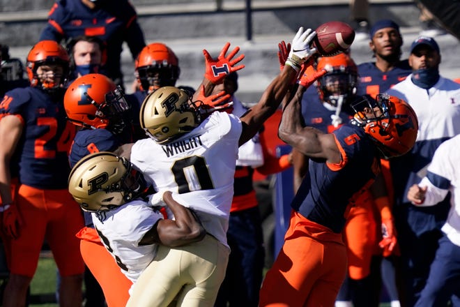 Purdue wide receiver Milton Wright (0) keeps Illinois defensive back Tony Adams (6) from intercepting a pass during the first half of an NCAA college football game Saturday, Oct. 31, 2020, in Champaign, Ill. (AP Photo/Charles Rex Arbogast)