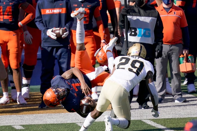 Illinois quarterback Coran Taylor (7) is upended by Purdue cornerback Simeon Smiley during the first half of an NCAA college football game Saturday, Oct. 31, 2020, in Champaign, Ill. (AP Photo/Charles Rex Arbogast)